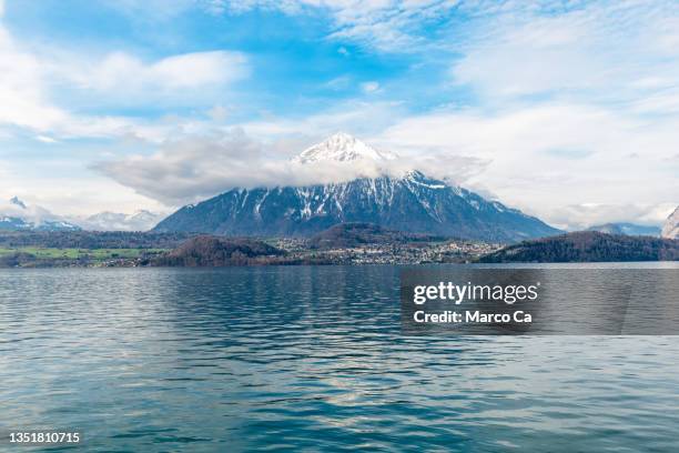 vista sobre el lago thun a la montaña niesen en los alpes suizos - lago thun fotografías e imágenes de stock