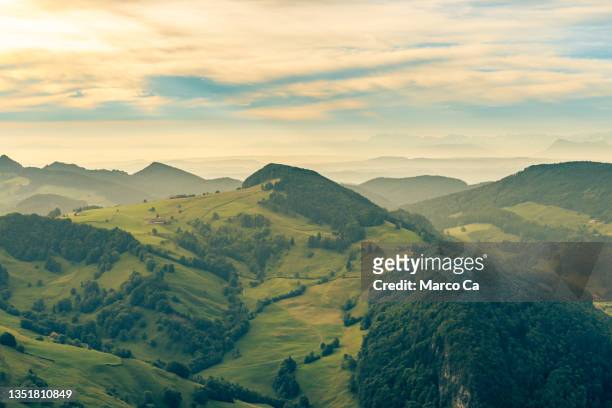 golden sunrise in the gentle mountain ranges of the jura mountains in switzerland - solothurn stockfoto's en -beelden
