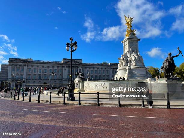 image of victoria memorial and buckingham palace, black and gold central ceremonial gates, crowds of tourists, sunny blue sky, the mall, london, england, uk - buckingham palace building stock pictures, royalty-free photos & images