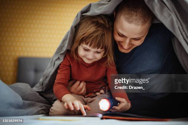 mother with cancer playing with daughter in bedroom - cancer patient with family stock pictures, royalty-free photos & images