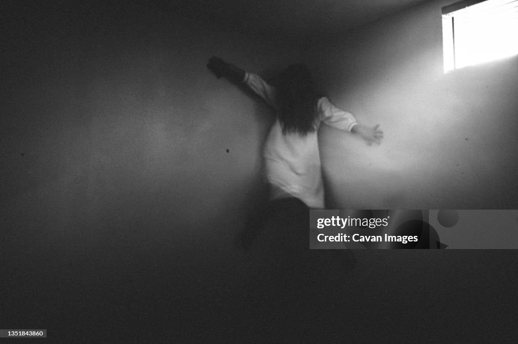 Scary ghost girl clinging to the corner of the walls