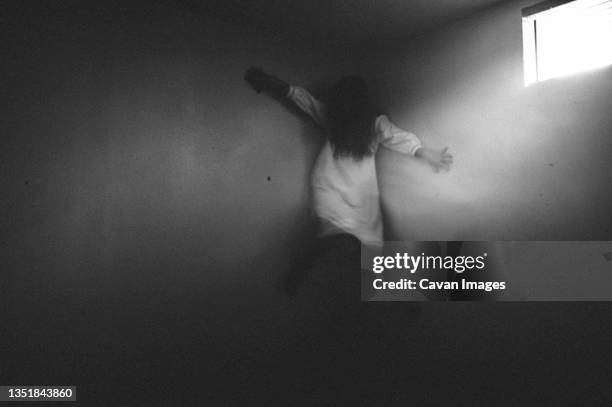 scary ghost girl clinging to the corner of the walls - demon stock pictures, royalty-free photos & images