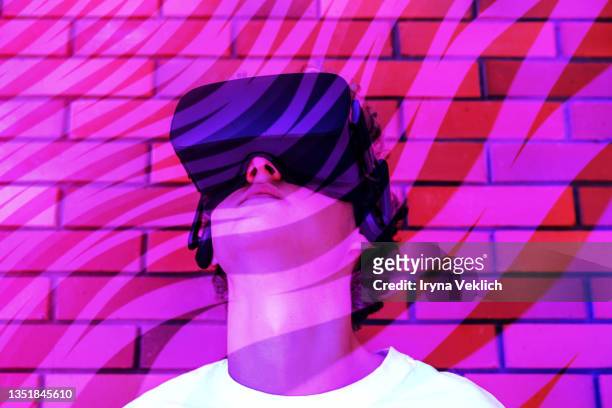 young man or teenager in a white t-shirt wearing virtual reality headset during the vr experience. - top prospects game stockfoto's en -beelden