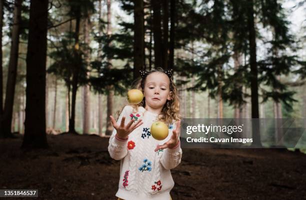 girl juggling apples in the forest in autumn - juggling stock pictures, royalty-free photos & images