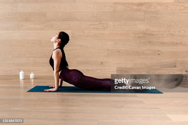 sporty fit yogini woman practices yoga asana bhujangasana - posen stockfoto's en -beelden