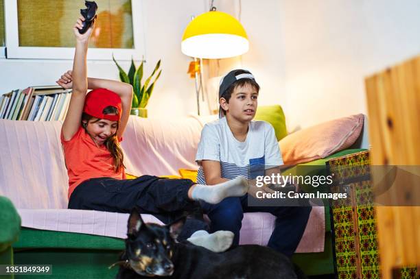 children playing video games at home - command sisters photos et images de collection