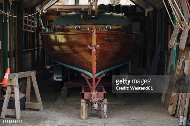 wooden boat in a boathouse - rimessa per barche foto e immagini stock