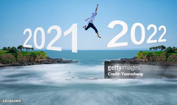 people jump from year 2021 to year 2022 - start of year stock pictures, royalty-free photos & images