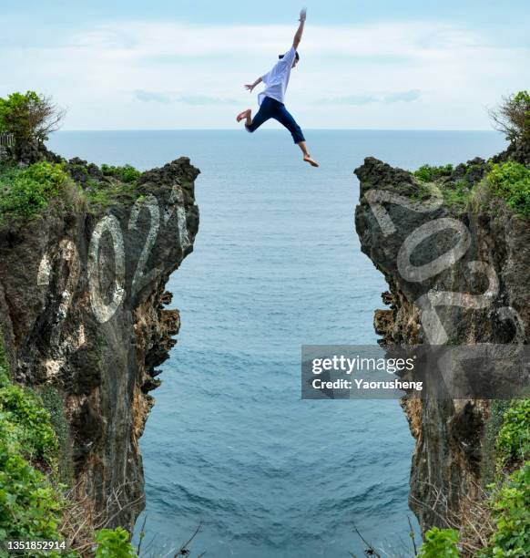 people jump from year 2021 to year 2022 - the end words stock pictures, royalty-free photos & images