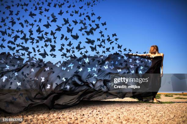 mysterious woman releasing butterflies in desert - blue dress bildbanksfoton och bilder