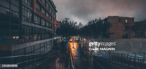 one asian young woman walking on the shanghai street with umbrella in a rainy night - wet stock pictures, royalty-free photos & images