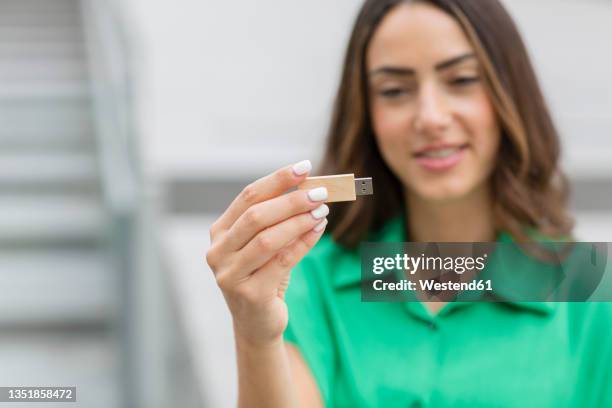 woman holding wooden usb stick - usb stick stock-fotos und bilder