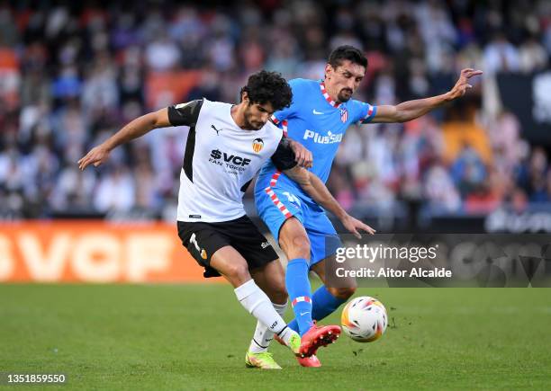 Goncalo Guedes of Valencia CF is challenged by Stefan Savic of Atletico Madrid during the La Liga Santander match between Valencia CF and Club...