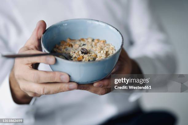 man's hands holding cereal bowl, close-up - muesli bildbanksfoton och bilder