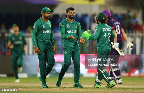 Shadab Khan of Pakistan celebrates the wicket of George Munsey of Scotland with team mates Babar Azam and Mohammad Rizwan during the ICC Men's T20...