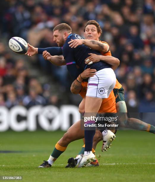 Scotland player Finn Russell is tackled by Wallabies players Len Ikitau and Michael Hooper during the Autumn Nations Series match between Scotland...