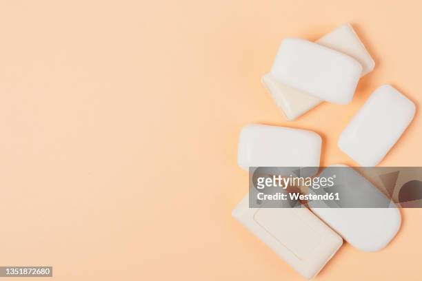 variety of soap bars on peach background - bar of soap stock pictures, royalty-free photos & images