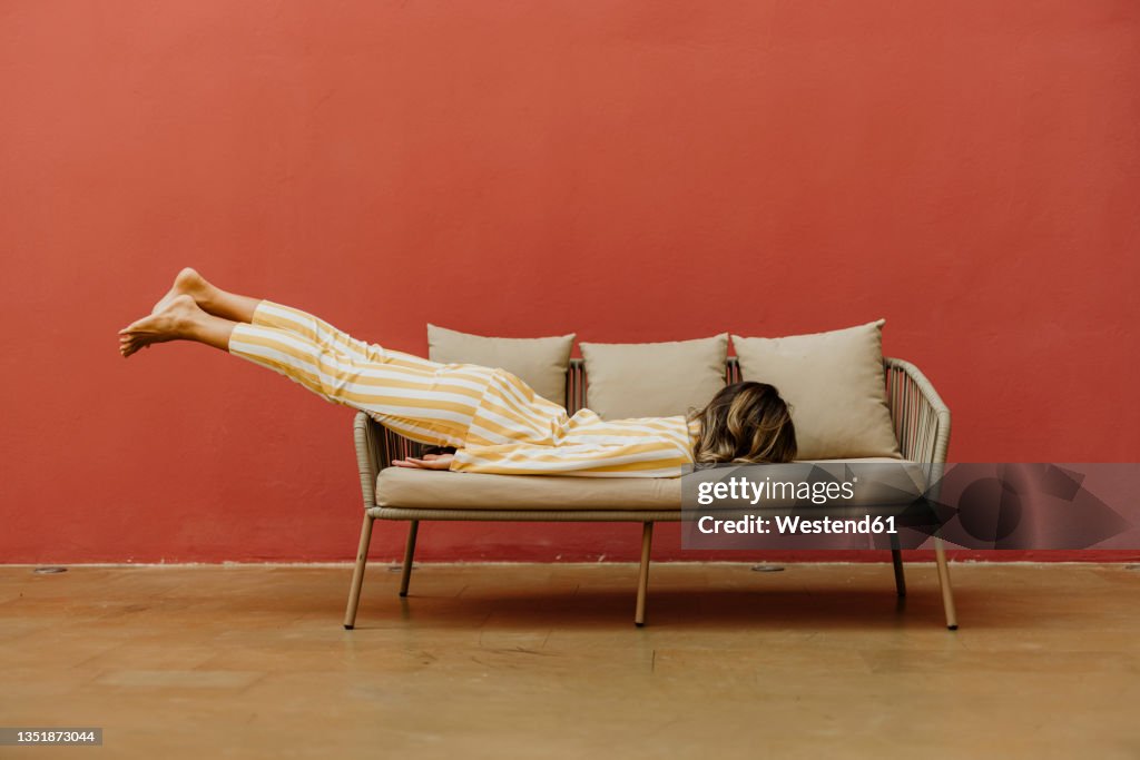 Tired young woman sleeping on sofa