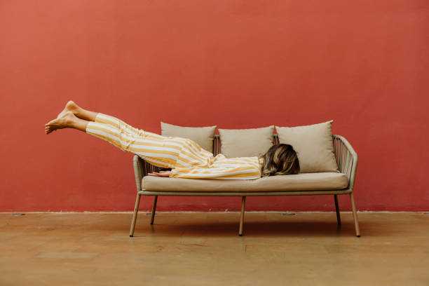tired young woman sleeping on sofa - 休む ストックフォトと画像