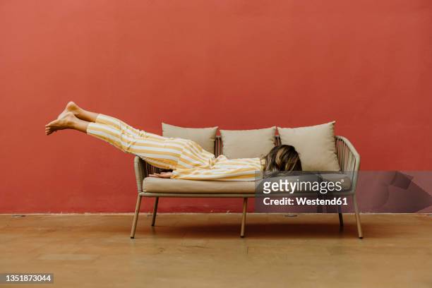 tired young woman sleeping on sofa - humor stockfoto's en -beelden