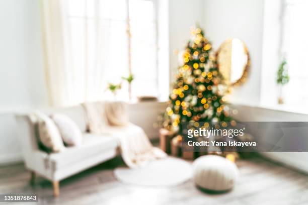 defocused background of a living room decorated for christmas with illuminated fir tree - pastel christmas stock pictures, royalty-free photos & images