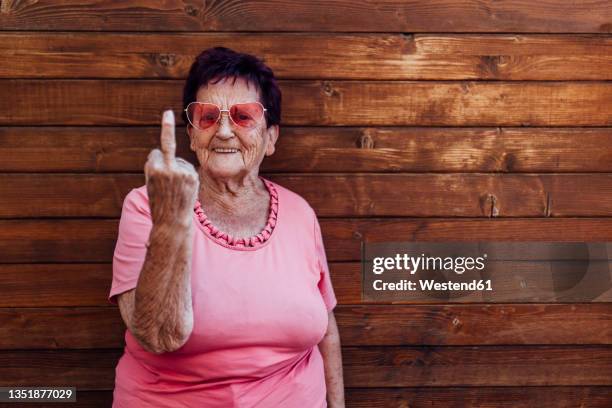 smiling woman gesturing in front of wall - doigt dhonneur 個照片及圖片檔