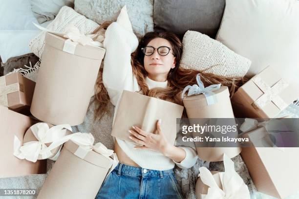 beautiful woman in glasses is reading a book, she is a bookworm enjoying the black friday sale offers - kaufsucht stock-fotos und bilder
