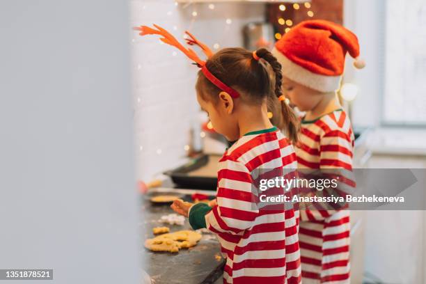 children in christmas costume pull out forms from the dough - flour christmas stock pictures, royalty-free photos & images