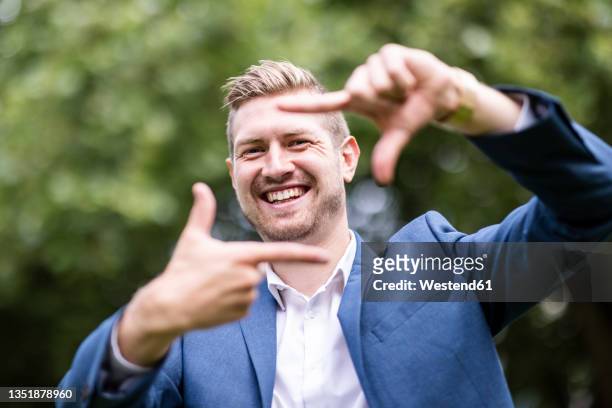 happy young businessman making finger frame - human finger stock pictures, royalty-free photos & images