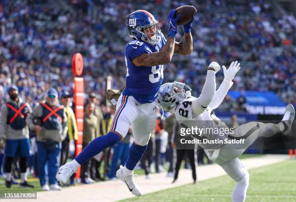 Evan Engram of the New York Giants scores a touchdown while defended by Johnathan Abram of the Las Vegas Raiders during the first quarter at MetLife...