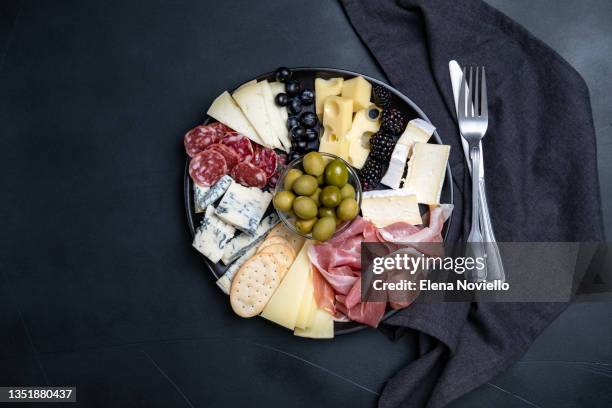 charcuterie board with italian salami, prosciutto, various cheeses and olives - charcuterie stockfoto's en -beelden