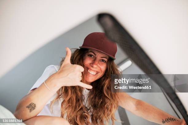 smiling woman with brown hair gesturing in camper van - belt stockfoto's en -beelden