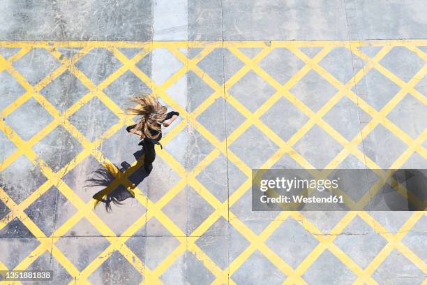 woman tossing hair while dancing on footpath - woman twirling stockfoto's en -beelden