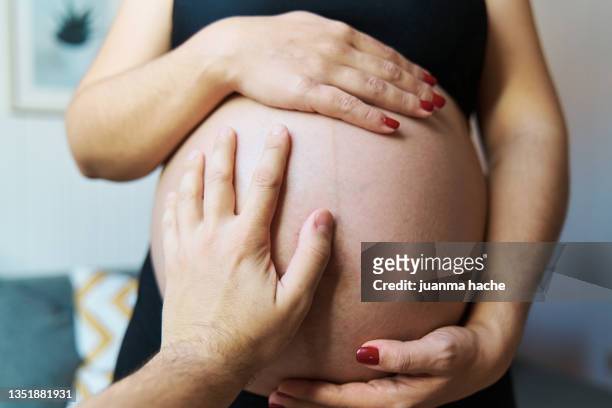 close up view of a pregnant couple touching and holding the baby belly. - pregnant belly stock-fotos und bilder