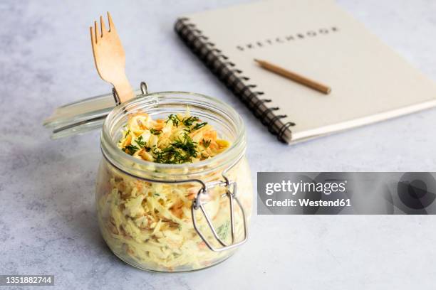 jar of grated vegetable salad with note pad in background - apio nabo fotografías e imágenes de stock