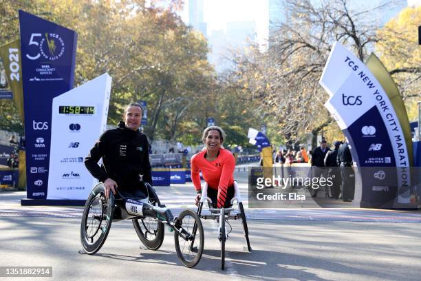 Wheelchair winners Marcel Hug of Switzerland and Madison De Rozario of Australia pose at the finish line during the 2021 TCS New York City Marathon...
