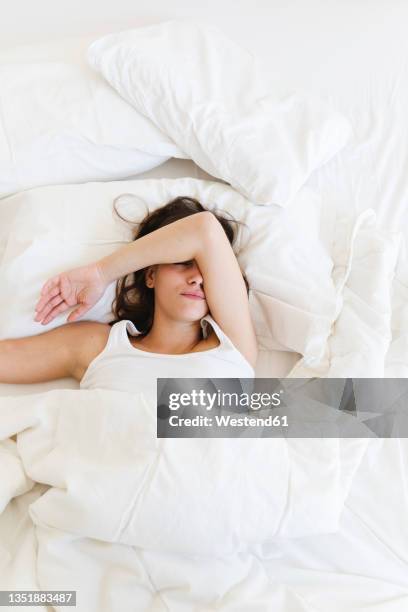 young woman sleeping on bed at home - bett schlafen stock-fotos und bilder