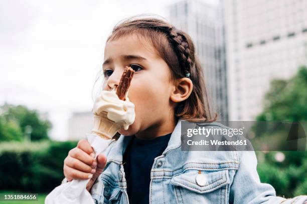 girl eating ice cream at public park - girl eating messy ice cream cone stock pictures, royalty-free photos & images