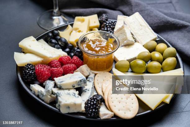 cheese board parmesan, pecorino, gorgonzola, brie cheese and berries, olives and jam and crackers. appetizer for wine, festive serving for dinner or lunch - cheese platter stock pictures, royalty-free photos & images