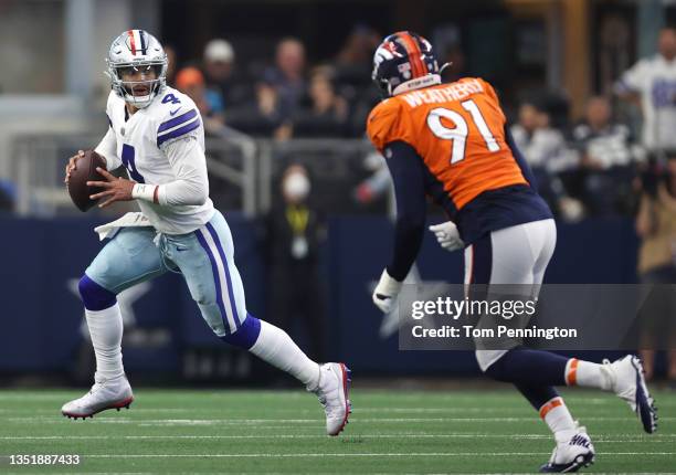 Dak Prescott of the Dallas Cowboys scrambles with the ball as Stephen Weatherly of the Denver Broncos pursues during the first quarter at AT&T...