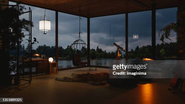 cozy lake house living room with lake view in evening - dusk stock pictures, royalty-free photos & images