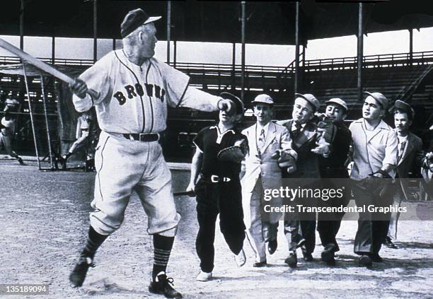 Hall of Famer Rogers Hornsby, manager of the St. Louis Browns pretends to fend off a group of Brownies, or little people, at a photo op at Sportsmans...