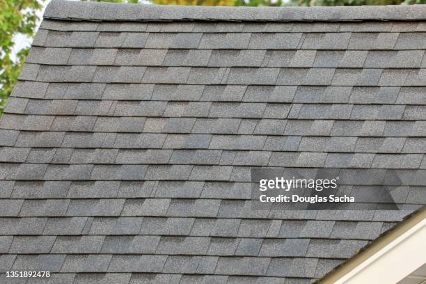 roofing shingles on a slanted rooftop - roof tile stock-fotos und bilder