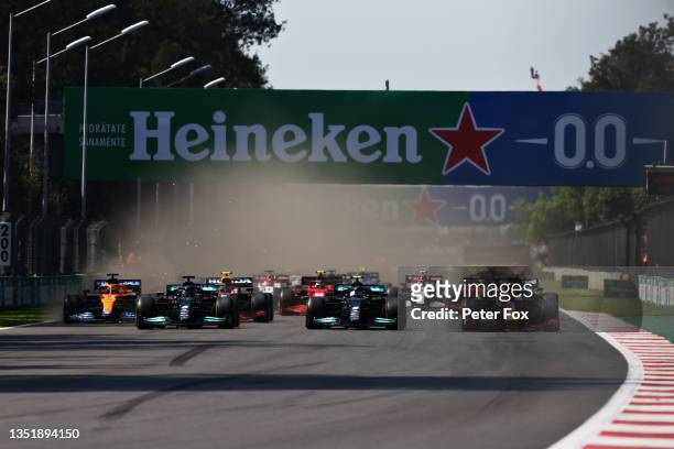 Max Verstappen of the Netherlands driving the Red Bull Racing RB16B Honda leads Lewis Hamilton of Great Britain driving the Mercedes AMG Petronas F1...