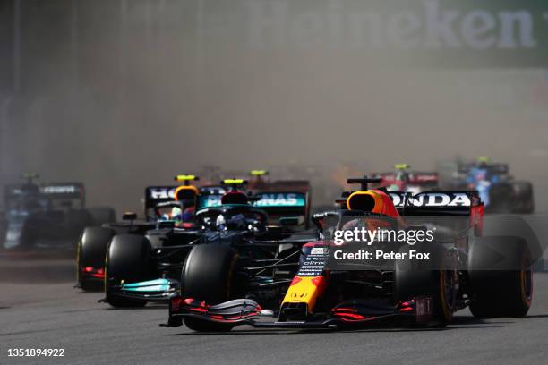 Max Verstappen of the Netherlands driving the Red Bull Racing RB16B Honda leads Lewis Hamilton of Great Britain driving the Mercedes AMG Petronas F1...