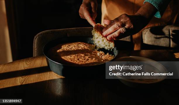 a woman cuts into a freshly baked homemade sponge to place in an empty bowl - serving dish stock pictures, royalty-free photos & images