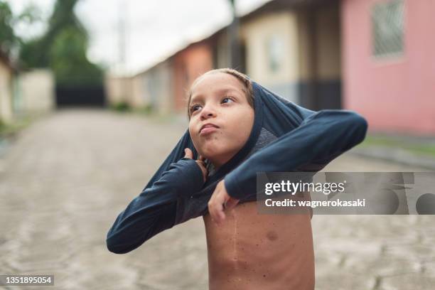 portrait of a boy with chest surgery scar putting on a shirt - heart surgery scar 個照片及圖片檔
