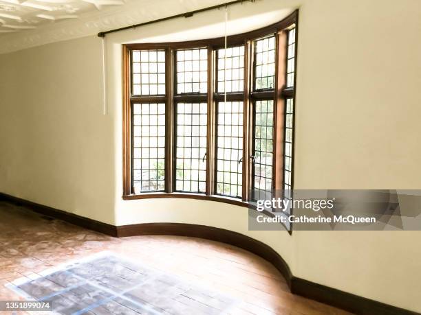 tudor home renovation: selecting color of new floor stain in front of leaded glass bay window - janela saliente - fotografias e filmes do acervo