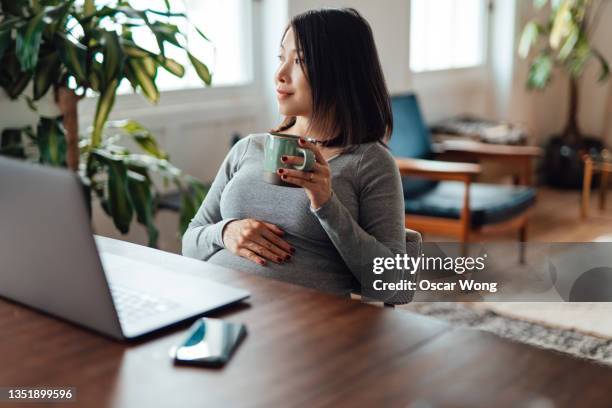 pregnant woman enjoying working from home - asian woman pregnant stockfoto's en -beelden