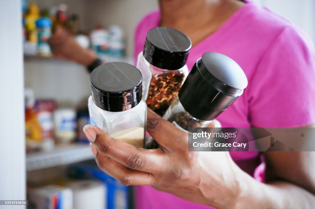 Woman Grabs Spices From Pantry